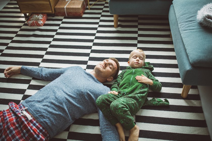 Vater und Sohn chillen nach Weihnachten auf dem Teppich
