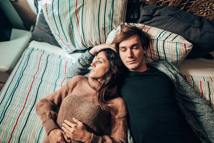 Nachdenkliches Pärchen liegt im Bett
