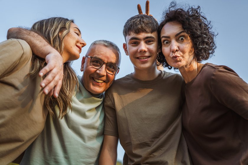 Portrait of caucasian family having fun and gesturing together in nature
