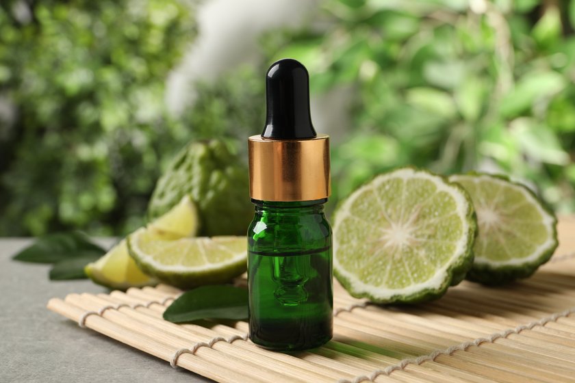 Glass bottle of bergamot essential oil on table