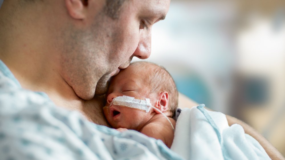 Ein Frühchen im Arm seines Vaters