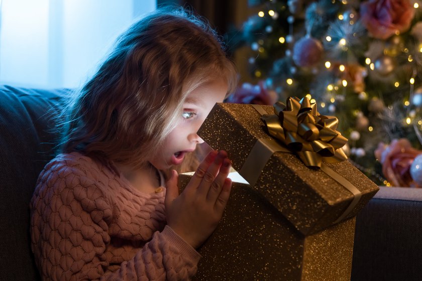 Little girl with opens Christmas gift