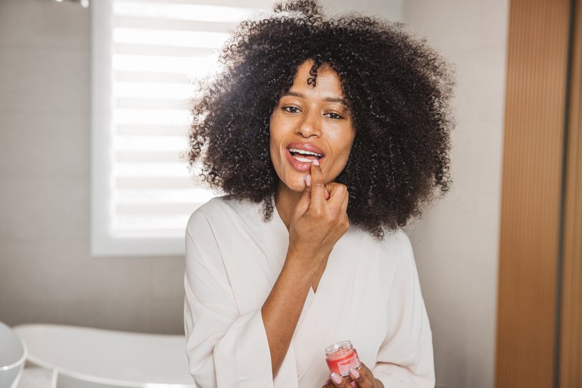 Frau trägt Lippenpflege auf