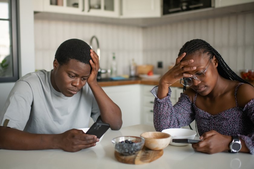 Paar frühstückt mit Smartphones in der Hand