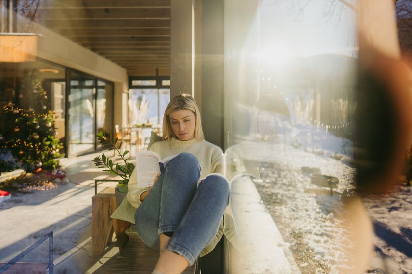 Junge Frau liest im Winter ein Buch